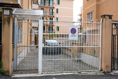 a gate with a no parking sign in front of a building at La Maison de la Couturière in Rome