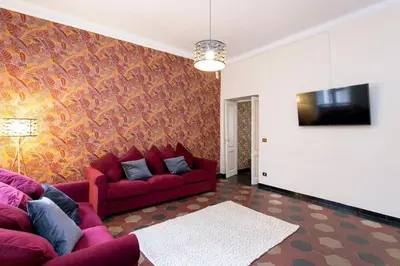 a living room with a red couch and a tv at Borgo Plauto Oasi di Eleganza vicino al vaticano in Rome