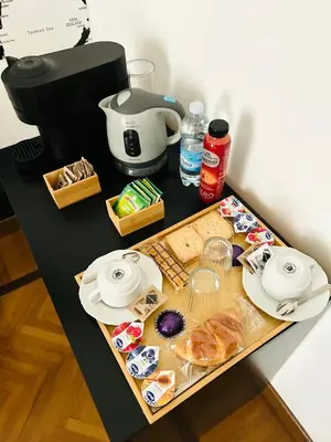 a table with a tray of food and a coffee maker at B&B Gelsomina Apartment in Rome