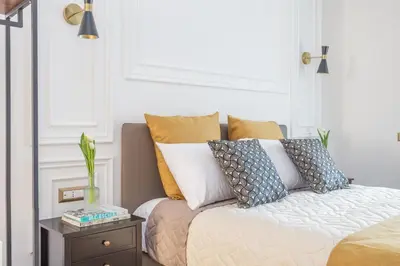 a bedroom with a bed with pillows and a table at Rhome Vatican Rooms in Rome