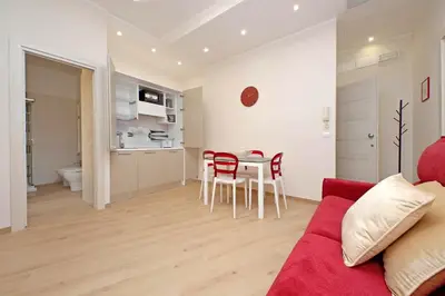 a living room with a red couch and a table and chairs at 4BNB - Ottaviano Vatican Flat in Rome