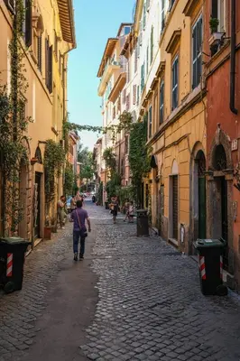a man walking down a street in an alley at Trastevere Characteristic Roman Home in Rome