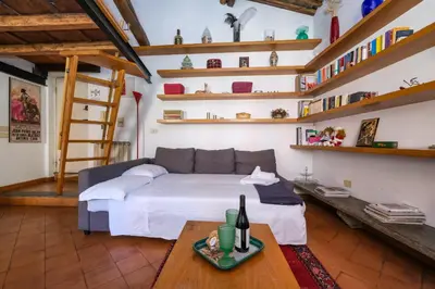 a bedroom with a bed and a table and shelves at Trastevere Characteristic Roman Home in Rome
