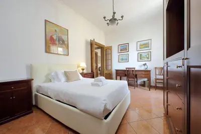 a bedroom with a large white bed and a desk at Etruria At San Giovanni by Halldis in Rome