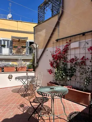 a patio with a table and chairs and plants at Residenza Brama - Art ApartHotel in Rome