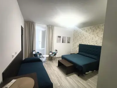 a room with a bed and a couch and a table at Nives House Roma in Rome