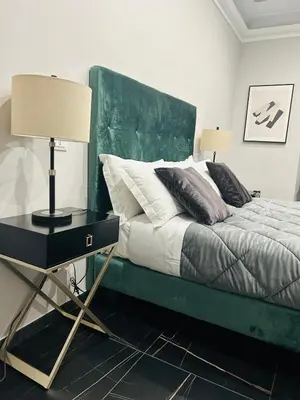 a bed with a green headboard and a table with a lamp at AD Vatican Luxury Rooms - by AD Roma in Rome