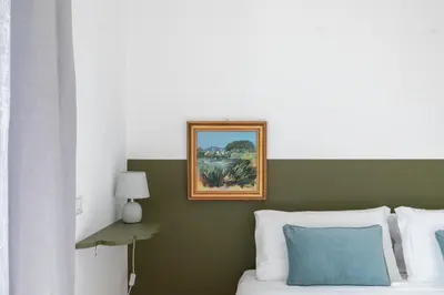 a bedroom with a bed with a painting on the wall at iFlat Cozy flat with a view in San Giovanni in Rome
