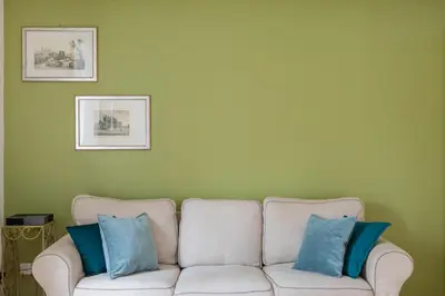 a white couch with two blue pillows on it at iFlat Cozy flat with a view in San Giovanni in Rome