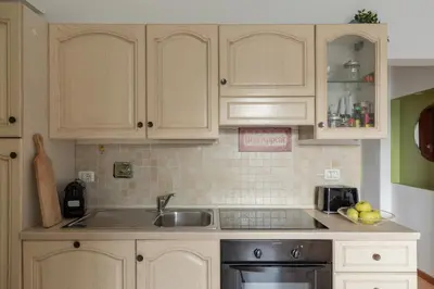 a kitchen with white cabinets and a sink at iFlat Cozy flat with a view in San Giovanni in Rome