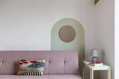 a living room with a purple couch and a mirror at iFlat Cozy flat with a view in San Giovanni in Rome