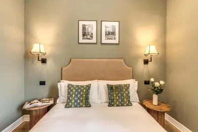 a bedroom with a bed with two side tables at Dimore Paganica in Rome