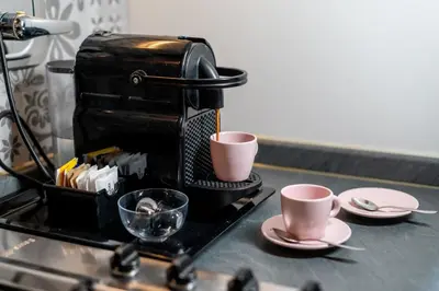 a coffee maker sitting on a counter with two cups at INTERNO 39 - San Pietro in Rome