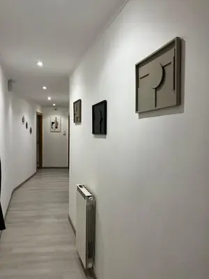 a hallway with paintings on a wall with a suitcase at Vatican Museum Scipioni BED & Breakfast in Rome
