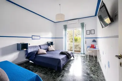a blue bedroom with a bed and a tv at Take It Easy Roma Guest House in Rome