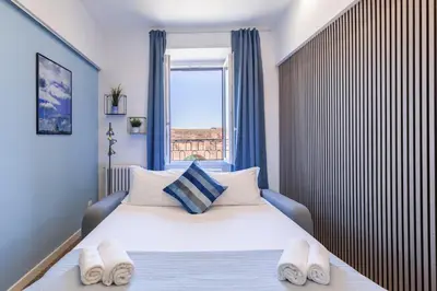 a bedroom with a large bed with slippers on it at Hostly-ColorHome Rome Midtown in Rome