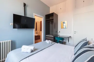a bedroom with a bed with a flat screen tv on the wall at Hostly-ColorHome Rome Midtown in Rome