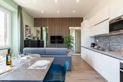 a kitchen and living room with a table and blue chairs at Hostly-ColorHome Rome Midtown in Rome