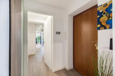 a hallway with white walls and a wooden door at Hostly-ColorHome Rome Midtown in Rome