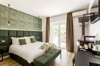 a bedroom with a large bed with a green headboard at Romi Suite in Rome
