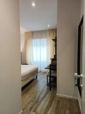 a bedroom with a bed and a desk in a room at Romi Suite in Rome