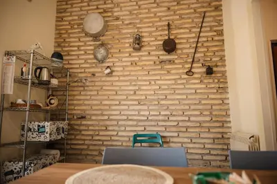 a brick wall in a room with a table and chairs at TWO-ROOM Apt. under the Aqueduct's ARCH in Pigneto in Rome