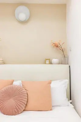 a white bedroom with a bed with pink pillows at Leonina Apt - Colosseum in Rome