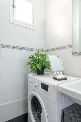 a white washing machine in a bathroom with a sink at Maison Blu - in Trastevere in Rome