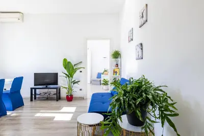 a living room with blue chairs and potted plants at Maison Blu - in Trastevere in Rome