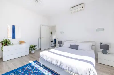 a white bedroom with a white bed and white cabinets at Maison Blu - in Trastevere in Rome
