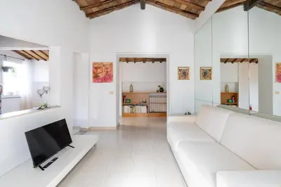 a living room with white furniture and a flat screen tv at [15 min from Piazza Venezia] Skyline Sanctuary in Trastevere in Rome