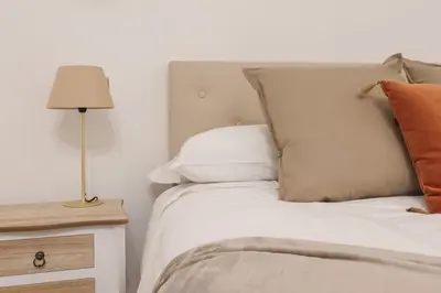 a bed with pillows and a lamp on a night stand at Vaticano - appartamento nuovo in Rome