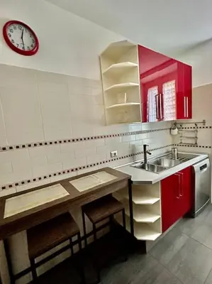 a kitchen with a sink and a clock on the wall at Angel House - balcony and view in Rome