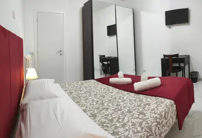 a bedroom with a large bed with red and white sheets at Stazione Telese 41 in Rome