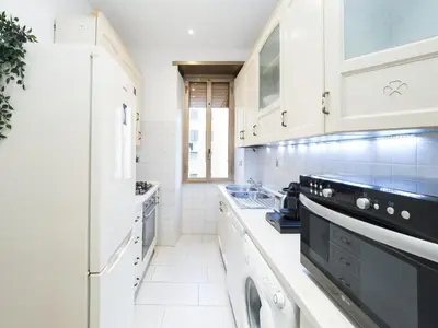 a kitchen with white cabinets and black appliances at {Colosseum 10 minutes} Netflix & Free Wi-Fi in Rome