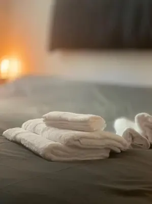 a stack of towels sitting on top of a bed at Monteverde Suites in Rome