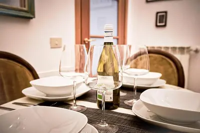 a bottle of wine sitting on a table with glasses at Monteverde Suites in Rome