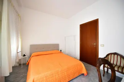 a bedroom with an orange bed and a chair at QUEEN VATICAN in Rome