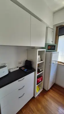 a kitchen with white cabinets and a refrigerator at Aroma Vaticano - Appartamento a San Pietro in Rome