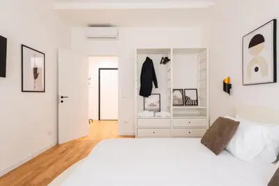 a white bedroom with a white bed and a closet at Ascanio's Cozy Apartment - by 101Flats in Rome