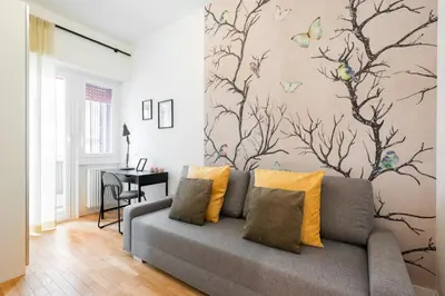 a living room with a couch and a wall with butterflies at Ascanio's Cozy Apartment - by 101Flats in Rome
