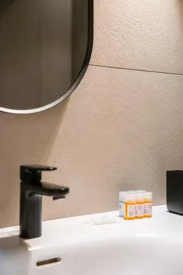 a bathroom sink with a mirror next to a sink at Ascanio's Cozy Apartment - by 101Flats in Rome