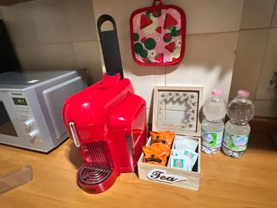 a red blender sitting on a counter next to a microwave at Apartment Albona 77 in Rome