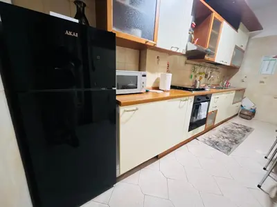 a kitchen with a black refrigerator and white cabinets at Apartment Albona 77 in Rome