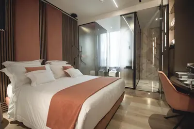 a bedroom with a large white bed and a desk at Tritone Luxury Suites Fontana di Trevi in Rome