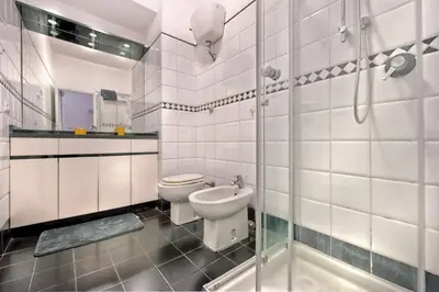 a white bathroom with a toilet and a shower at Appartamento Romantico a Trastevere in Rome