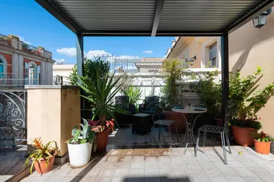 a patio with a table and chairs and plants at Hotel de' Clementi in Rome