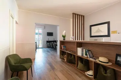 a living room with a book shelf and a chair at Hotel de' Clementi in Rome