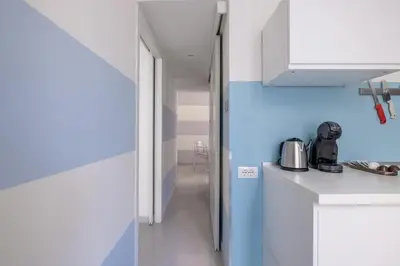 a kitchen with white counters and a blue wall at Vatican Apartment near Metro Ottaviano in Rome
