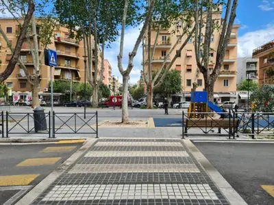 a empty street with benches and trees and buildings at Casina Valtellina in Rome